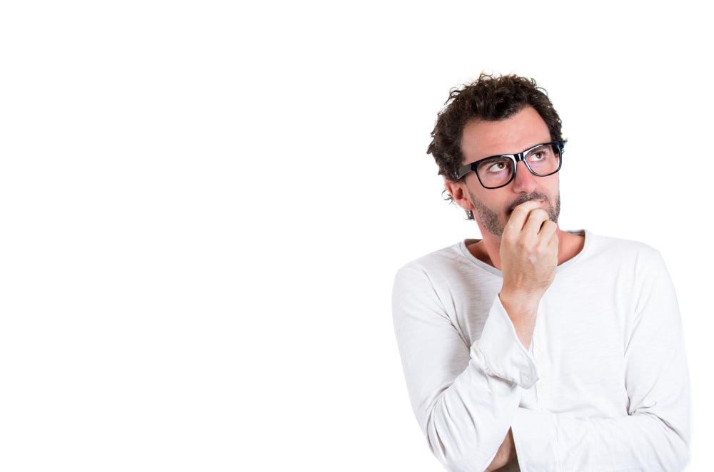 Closeup portrait of handsome young man, wearing black glasses, daydreaming, deep in thought  looking up and to side, isolated on white background with copy space. Human emotions and facial expressions