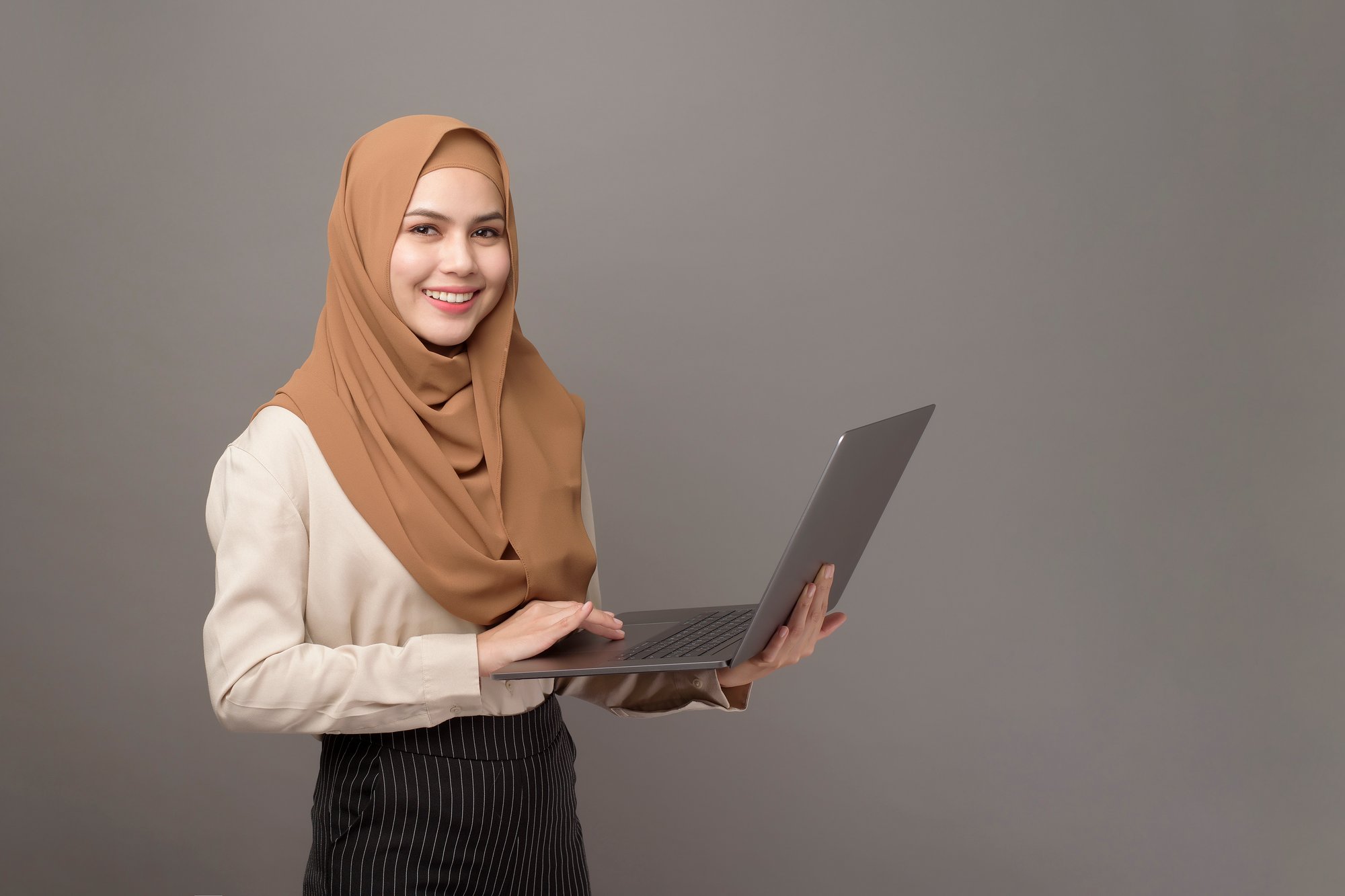 portrait-of-beautiful-woman-with-hijab-is-holding-computer__203